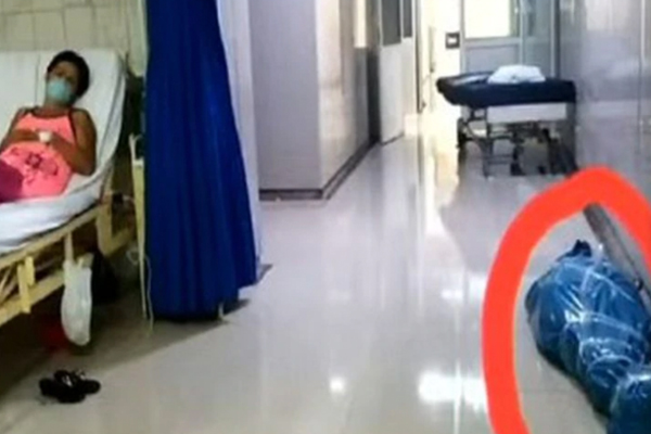 En una de las fotos se aprecia a una paciente convaleciente durmiendo en una camilla mientras se ve a un cuerpo sin vida al lado. (Foto difusión)