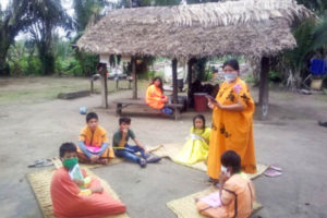 Mujer ayuda a niños de comunidad ashaninka a que continúen sus clases en el programa Aprendo en Casa. (Foto difusión)