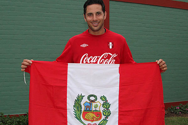 El futbolista junto a la bandera del Perú. (Foto difusión)