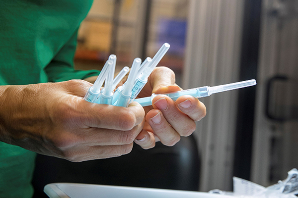 Una operaria de la planta de la empresa Becton Dickinson de Fraga (Huesca) inspecciona unas muestras de la jeringuilla que fabrican para administrar la vacuna contra el coronavirus. (Foto: EFE/Javier Cebollada)