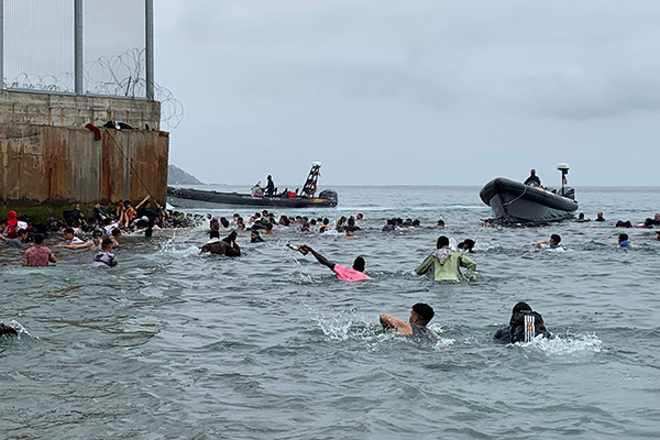 Un grupo de personas tratan de llegar a nado desde la playa de la localidad de Fnideq (Castillejos, Marruecos) hacia uno de los espigones de Ceuta este martes en una avalancha de inmigrantes sin precedentes en España al registrarse la entrada en 24 horas de 5.000 personas (un tercio de ellas menores). (Foto: EFE/ Mohamed Siali)
