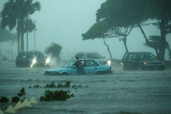 Vehículos fueron registrados este miércoles al circular bajo la intensa lluvia, durante el paso de la tormenta tropical Fred, sobre Santo Domingo (República Dominicana). (Foto: EFE/Orlando Barría)