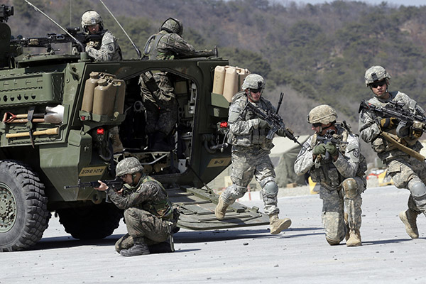 FILE - In this March 25, 2015, file photo, U.S. Army soldiers from the 25th Infantry Division's 2nd Stryker Brigade Combat Team and South Korean soldiers take their position during a demonstration of the combined arms live-fire exercise as a part of the annual joint military exercise Foal Eagle between South Korea and the United States at the Rodriquez Multi-Purpose Range Complex in Pocheon, north of Seoul, South Korea. The Pentagon says the annual U.S.-South Korean military exercises that had been postponed for the Pyeongchang Winter Olympics will begin April 1. (AP Photo/Lee Jin-man, File)