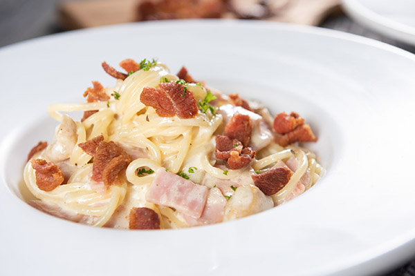 Spaghetti carbonara with bacon or Pasta white cream sauce with grilled bacon served on a white plate. Good tasty, not spicy and suit for all. Good food for good health and start to good day